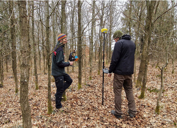 Zwei Wissenschaftler mit Geräten im Laubwald